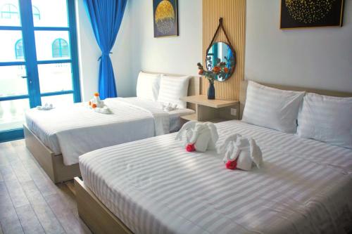 dos camas con animales de peluche en una habitación de hotel en Elene Phu Quoc en Phu Quoc