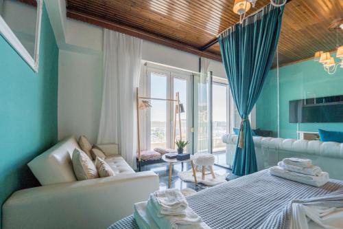 a room with a bed and a couch and a window at Aura Celestia in Kavala