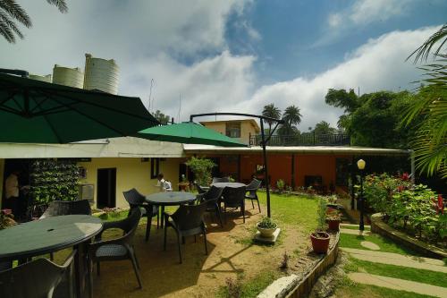 a patio with tables and chairs and a building at Hotel Shiv Villa in Mount Ābu