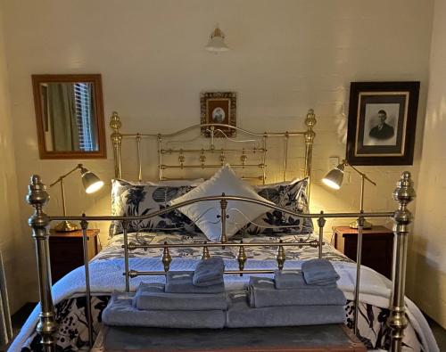 Battunga Cottages في Watervale: غرفة نوم عليها سرير وفوط زرقاء