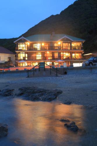 a large building with lights on at night at Oppiesee Selfcatering Apartments in Herolds Bay