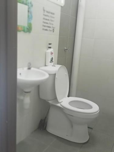 La salle de bains est pourvue de toilettes et d'un lavabo. dans l'établissement Alif Homestay Changlun, à Changlun