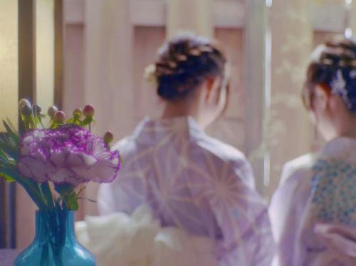 a woman is looking at a vase with flowers at Villa Sacra ヴィラサクラ in Kamakura