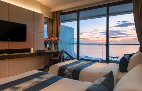 a hotel room with two beds and a view of the ocean at Queen Ann Nha Trang Hotel in Nha Trang