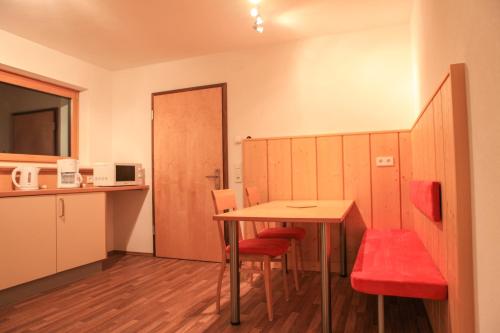 a room with a table and chairs and a kitchen at Apart Sportiva in Klösterle am Arlberg