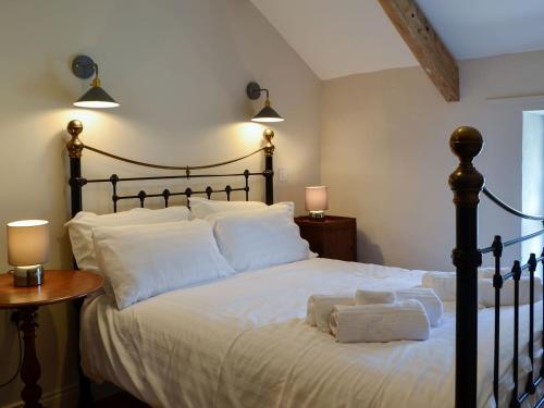 a bedroom with a large bed with white sheets and pillows at Troedyrhiw Isaf in Tregaron