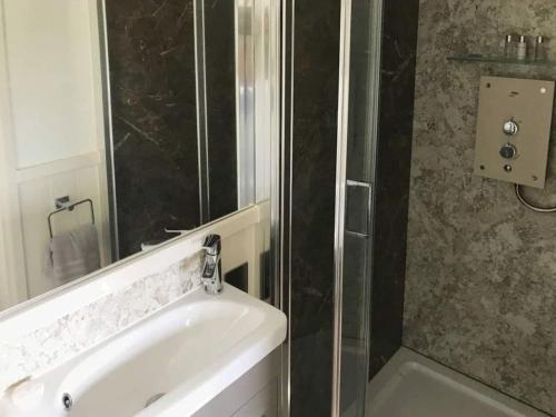 a bathroom with a shower and a sink and a tub at Sage - UK36937 in Lamerton