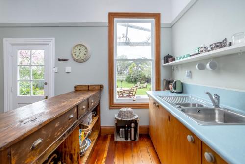 a kitchen with a counter and a sink and a window at Villa Florence in Martinborough