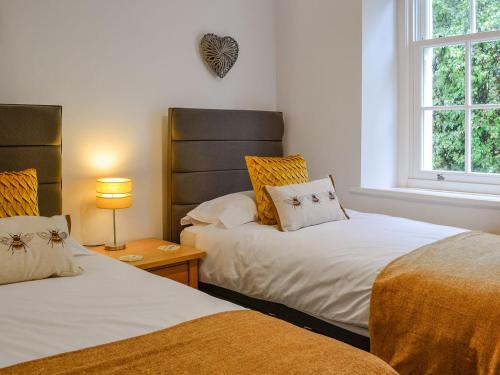 Duas camas sentadas uma ao lado da outra num quarto em Howbeck Cottage em Hesket Newmarket