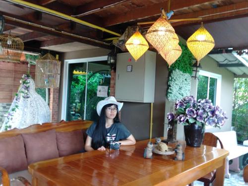 a woman sitting at a table in a restaurant at Ruenthip Homestay in Bangkok