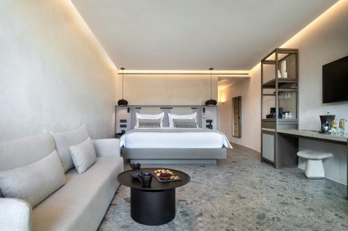 a hotel room with a bed and a couch at Aeonic Suites and Spa in Mýkonos City