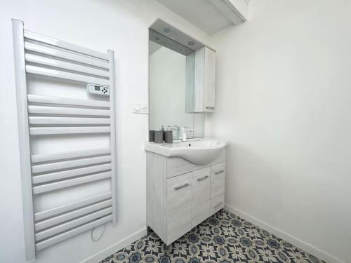 een witte badkamer met een wastafel en een spiegel bij Une nuit royale / Proche Forêt in Veneux-les-Sablons
