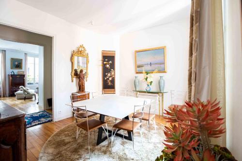 une salle à manger avec une table et des chaises blanches dans l'établissement Veeve - Artful Elegance, à Paris
