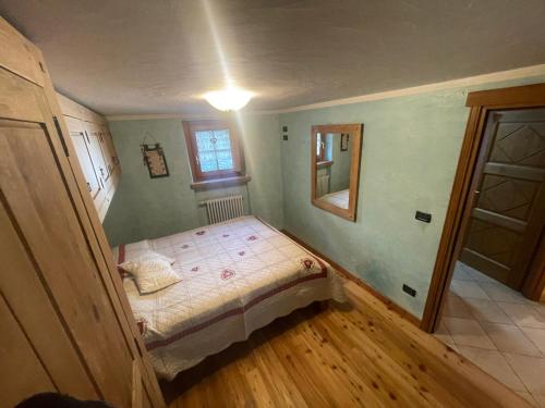 a small bedroom with a bed and a window at Bilocale pietra e legno immerso nella natura in Morgex