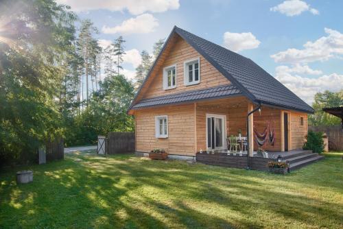 a small house with a black roof on a yard at Kotula in AdamÃ³w