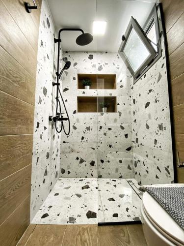 a bathroom with a shower with a rock wall at Tzoka Studio in Ierapetra