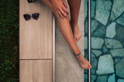 a woman with a pair of sunglasses sitting on a surfboard at Gasthof Residence Brugghof & Erlhof in Campo Tures