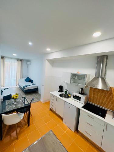 eine Küche und ein Wohnzimmer mit einem Tisch und einem Sofa in der Unterkunft ESTUDIOS RUDA 4 in Madrid