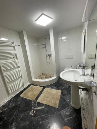 a bathroom with a shower and a tub and a sink at Haus Diel - Premium Apartments mit Küche in Pettneu am Arlberg