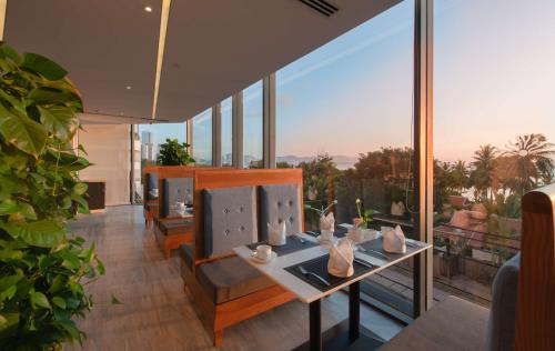 a living room with a table and chairs and glass windows at Queen Ann Nha Trang Hotel in Nha Trang