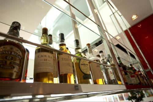 a row of wine bottles in a display case at Devero Hotel & Spa, BW Signature Collection in Cavenago di Brianza