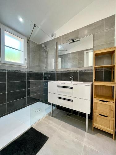 une salle de bain avec un lavabo blanc et une douche dans l'établissement Maison neuve au calme idéale pour 4 voyageurs, à Les Sables Vignier