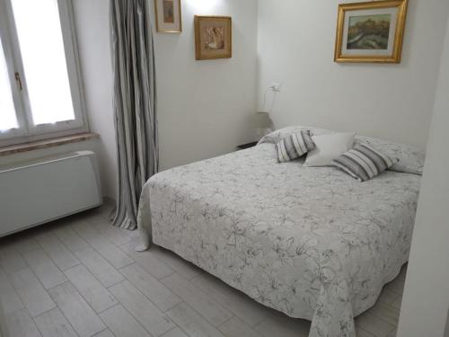 a white bedroom with a bed and a window at Il CORTILETTO Casa Vacanza Trevi in Trevi