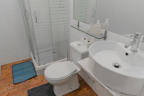 a bathroom with a toilet and a sink and a shower at Ndussole Guest House in Porto