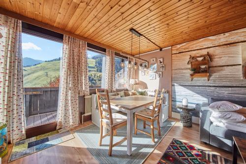 a dining room with a table and chairs and a large window at Appartement Kogelblick in Saalbach Hinterglemm
