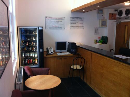 a bar with a desk with a computer on it at Colliers Hotel in London