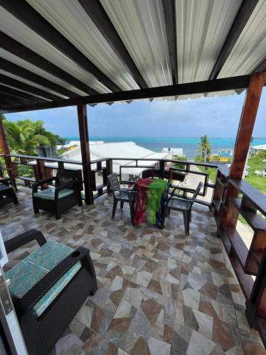 a patio with chairs and tables and a view of the ocean at Posada Ashanty in Providencia