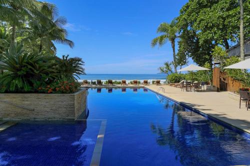 uma piscina com vista para o oceano em Juquehy Praia Hotel em Juquei
