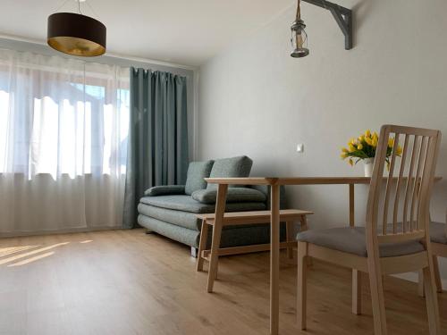 a living room with a couch and a table and chairs at Chiemsee Apartments in Altenmarkt an der Alz