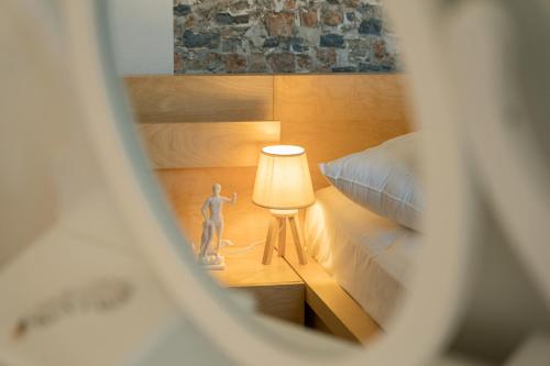 a room with a bed and a table with a lamp at Aura Celestia in Kavála