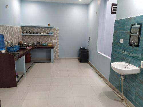 y baño con lavabo blanco y encimera. en Swapnil Homestay, en Varanasi