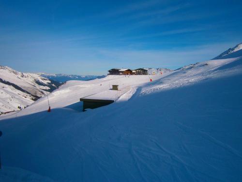 a snow covered mountain with a building on top of it at Panorama Lodge Hochfügen in Fügenberg