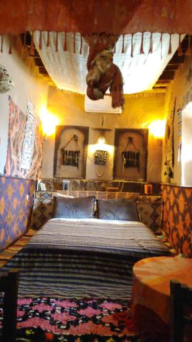 - une chambre avec un grand lit dans l'établissement Kasbah Maktob Tamnougalt, à Agdz