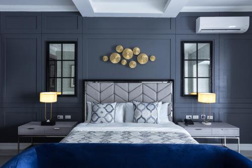 1 dormitorio con paredes azules y 1 cama con 2 lámparas en Stonehill Suites en Bacolod