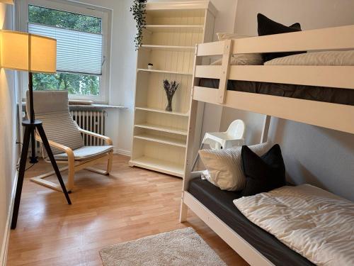 a room with two bunk beds and a chair at Wohnung in Wuppertal Elberfeld in Wuppertal