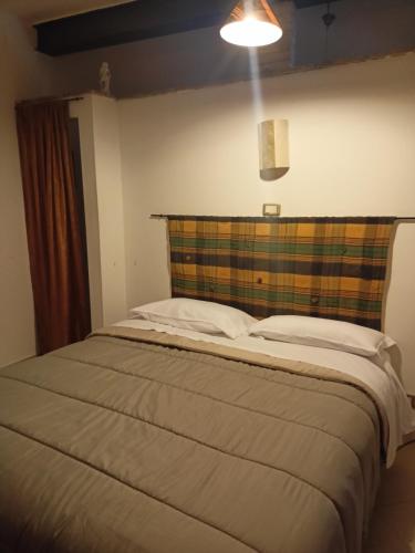 a bedroom with a large bed with a plaid headboard at Dimora Volturno in Vasto