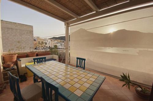 a patio with a table and chairs on a balcony at Casa Emma in Favignana
