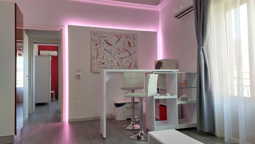 カステッランマーレ・デル・ゴルフォにあるEmporiumのピンクの天井の客室で、ピンクのライトが付いています。