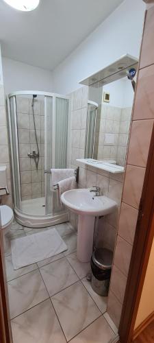 a bathroom with a sink and a shower at Hotel SYM in Ploieşti