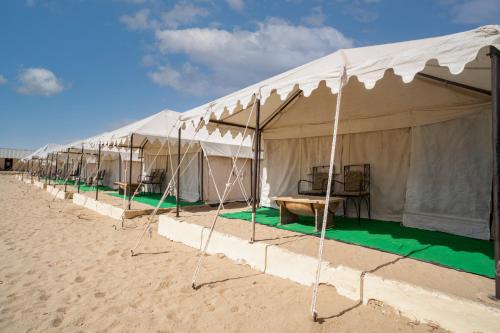 a row of tents on a sandy beach at Bhati Desert Camp Sam in Jaisalmer