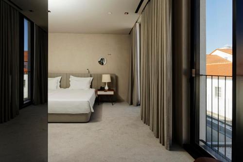 a hotel room with a bed and a window at Montebelo Vista Alegre Ílhavo Hotel in Ílhavo