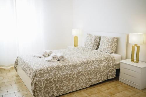 a bedroom with a bed with two towels on it at Host Wise - Sweet & Sunny Flat - Ace Location in Quarteira