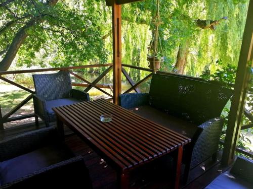 a screened in porch with a wooden table and chairs at Cango Retreat Quiet in Oudtshoorn