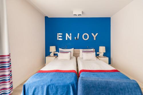 two beds in a room with a blue wall at Estilo Fashion Hotel Budapest in Budapest