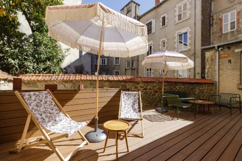 two chairs and a table and an umbrella on a deck at La Loge Gogaille - Préfecture - Accès autonome in Limoges