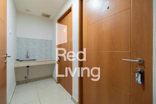 baño con puerta marrón y lavamanos en RedLiving Apartemen Evenciio - WIN Property Tower 1, en Depok